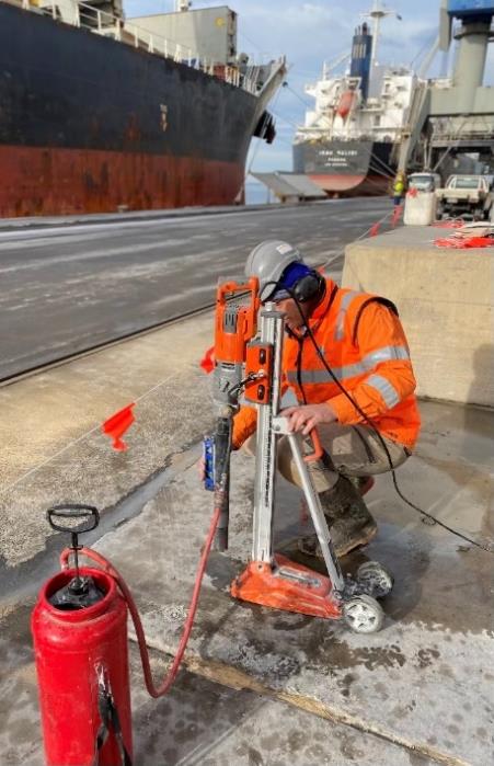 A worker drills and collects concrete cores from the surface of the completed Lascelles Wharf, Australia, to perform independent testing.